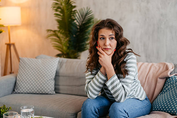 istock Sad Young Woman Sitting At Home On The Sofa 2218266707