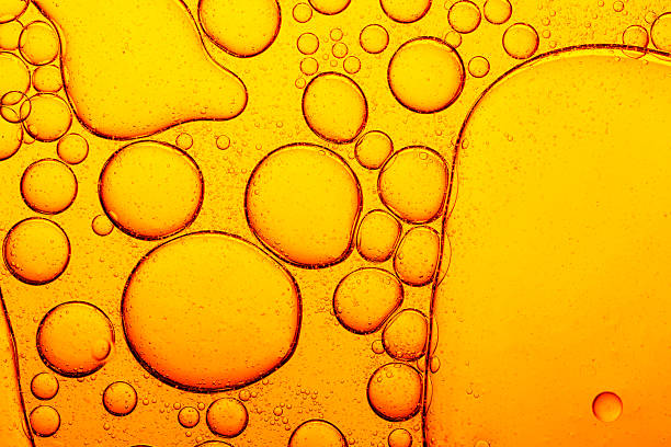 Macro close up yellow oil bubble texture,Gold Oil bubbles close up. circles of orange water macro. abstract shiny yellow background.