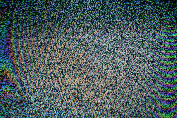 Close-up view of classic analog television noise shown on a screen, displaying a snowy pattern.