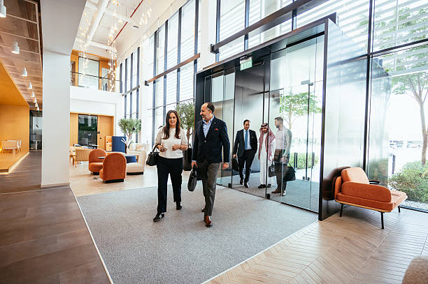 istock A diverse group of business professionals engage in a conversation inside a modern office setting with glass walls 2218273006