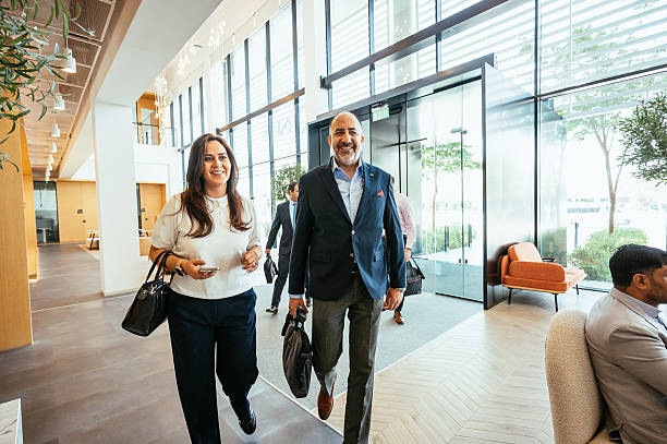 istock A diverse group of business professionals engage in a conversation inside a modern office setting with glass walls 2218273289