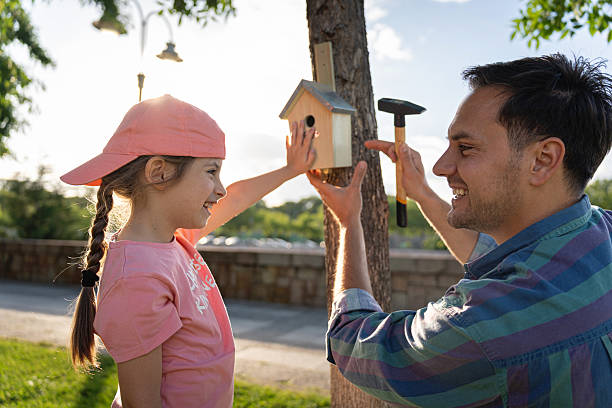 istock Father and daughter bonding while installing a birdhouse on a tree 2218273385