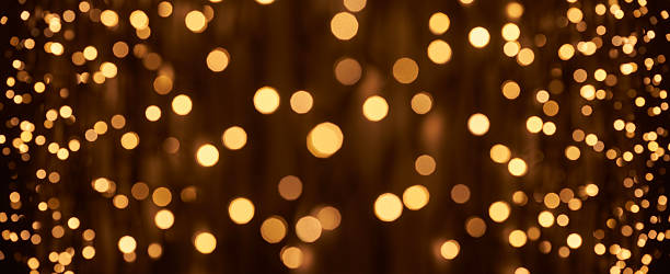 Golden Bokeh Light Circles on a Dark Background Creating a Warm and Festive Abstract Holiday Atmosphere