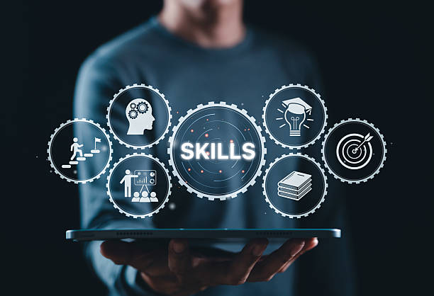Skills Development and Professional Training Concept. Businessman holds tablet displaying gear icons with word 