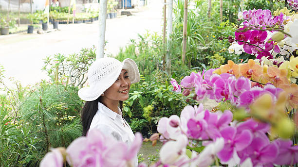 istock Woman Surrounded by Blooming Orchids 2218279851