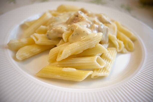 istock Penne pasta with carbonara sauce on white plate 2218281645