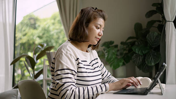 istock Asian Woman Stretching While Working on Laptop – Office Break Moment. 4k 2218281958