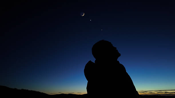 istock Silhouette of a man observing Milky Way stars, planets and other celestial objects from a dark countryside location. 2218282441
