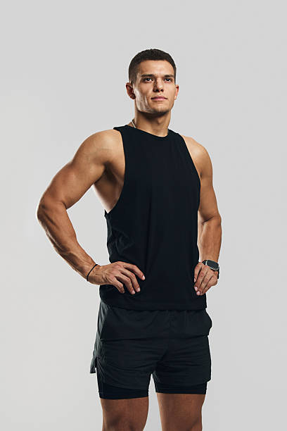 istock Confident athletic man in sportswear standing and posing against gray studio background 2218288360