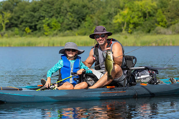 istock Young Boy & Dad Holding Fish Caught From Kayak 2218288958