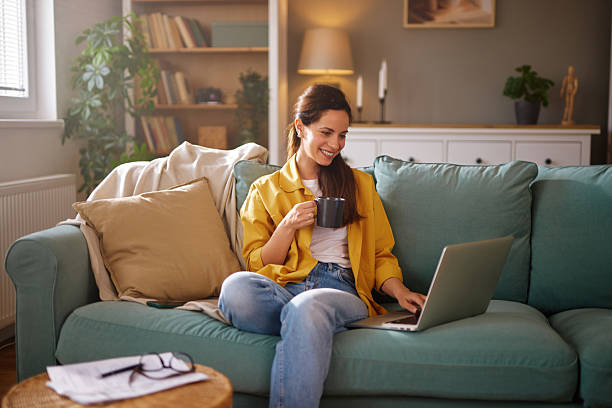istock Young woman working remotely from home, drinking coffee and using laptop 2218291741