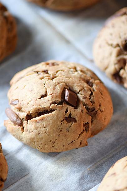 Close-up and wide-angle shots of delicious homemade chocolate chip cookies baking in the oven. The golden brown cookies with melting chocolate chunks are shown on parchment paper inside a modern oven. The warm lighting and cozy kitchen setting evoke the feeling of comfort food and homemade treats.
