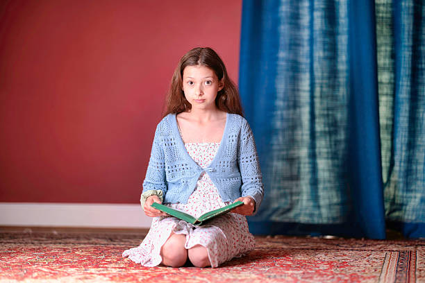 Pre-teen girl at home reading.
