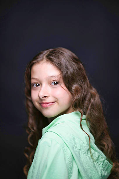 Portrait of a smiling eleven-year-old girl with long brown hair
