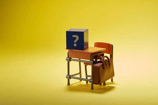 small toy school desk and chair with cube with question mark