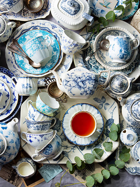 Vintage Blue and white pattern tea cups, plates, teapot and dinnerware on grey tablecloth. Top view.