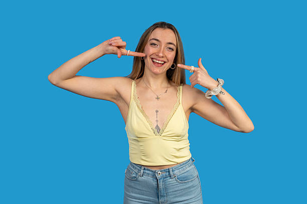 istock Young woman pointing at her smiling face on blue background 2218309265