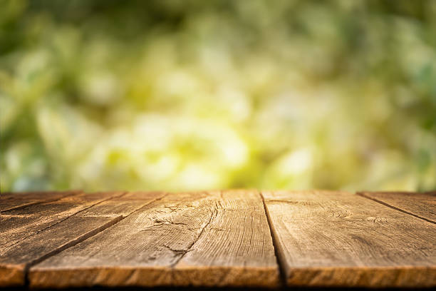 istock Rustic wooden tabletop with a blurred green forest background, ideal for displaying natural products, outdoor meals, or seasonal content in a warm and organic setting 2218310719