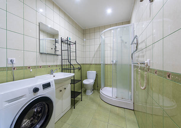 istock Modern Bathroom with Shower, Washing Machine, and Tiled Walls 2218311380