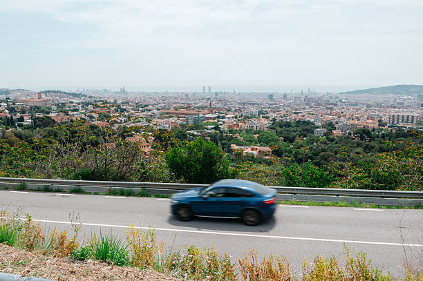 A car in blurred motion with Barcelona in the background
