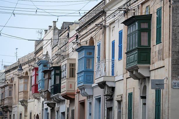 Young woman explores colourful, narrow streets in old town, Birgu, Valetta