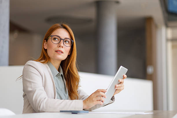istock Pensive businesswoman analyzing data on a digital tablet while working in a modern office, embodying professionalism and technology 2218317162