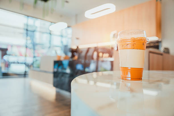 Refreshing iced drink on a marble table in a modern cafe setting with bright light and stylish decor