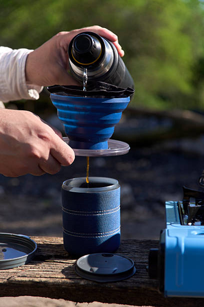 istock Coffee making: a man pours hot water into a folding filter with ground coffee 2218320001