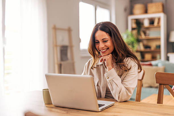istock Young woman working from home and smiling at laptop 2218322065