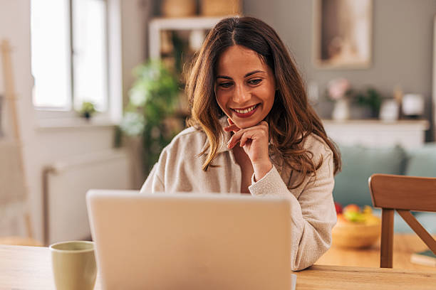 istock Young woman working from home on laptop and smiling 2218322066