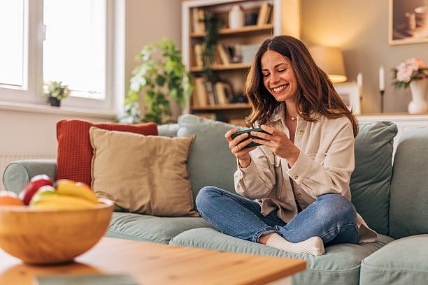 istock Woman relaxing on sofa playing mobile game at home 2218322174