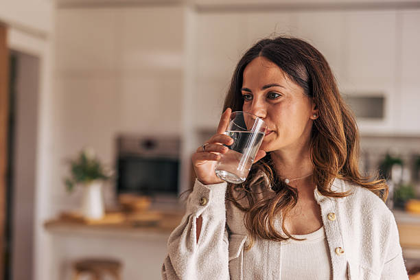 istock Woman drinking fresh water in the kitchen 2218322872
