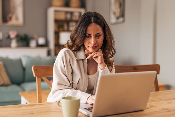 istock Focused woman working remotely from home office using laptop 2218323046