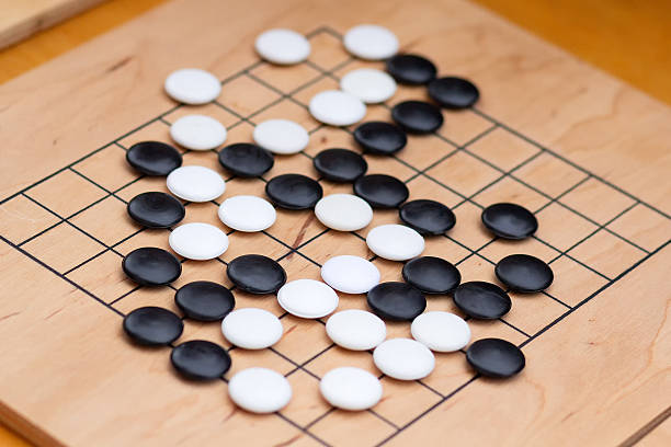 istock Chinese go game board, close up view of playing black and white stone pieces, Alphago 2218323621