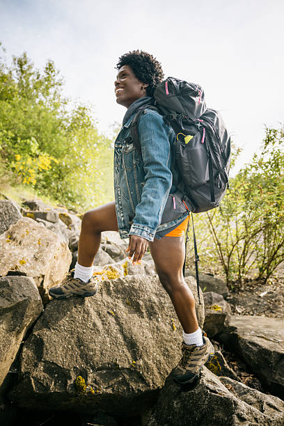 An African American woman enjoys hiking in Washington state, taking in the beauty of the Pacific Northwest.  Backpacker lifestyle of exploration and new sights and wonders.