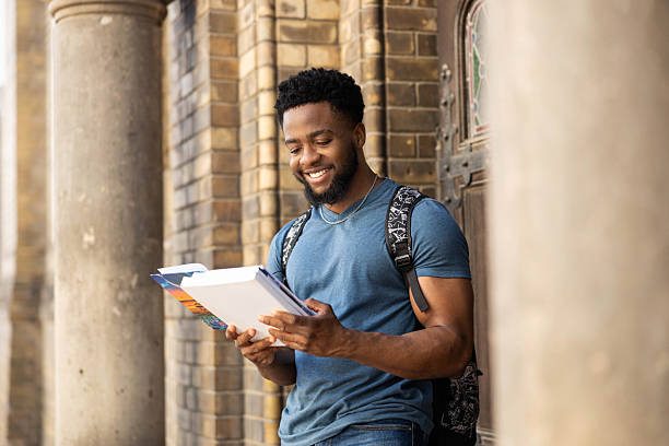 istock Cheerful man reading books by the door 2218325460