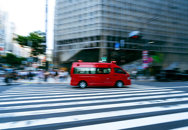 Red Tokyo Fire Department van crossing city intersection