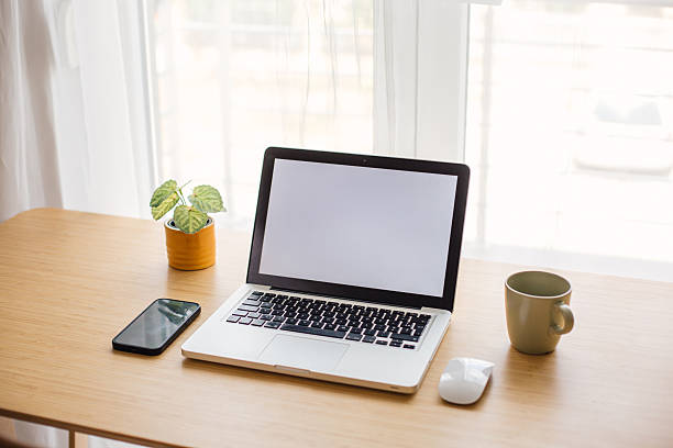istock Laptop with blank screen on wooden desk in home office setup 2218326246