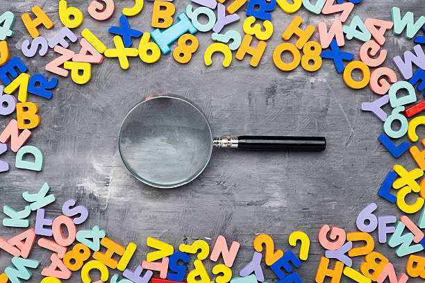 istock magnifying glass surrounded by colorful letters and numbers. Poor vision concept. 2218329798