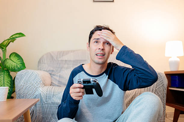 istock Frustrated Gamer Sitting at Home with Controller 2218331958