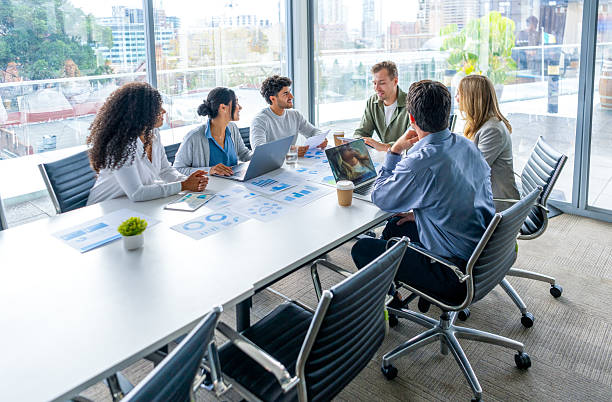 istock Multi racial diverse group of people working with Paperwork on a board room table at a business presentation or seminar. 2218333041
