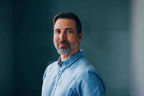 Confident Mature Man Smiling in Professional Attire with a Calm Background