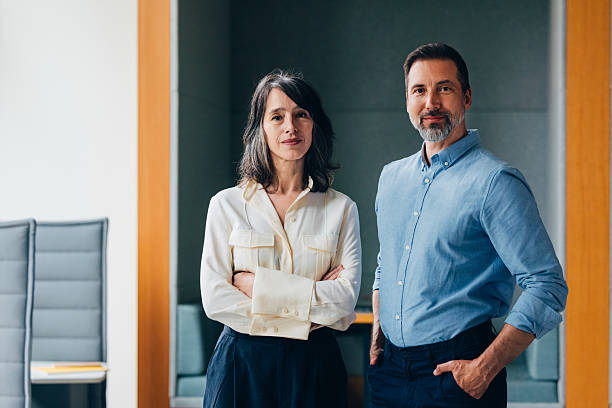 istock Confident Professional Man and Woman Smiling in Modern Office Setting 2218333127