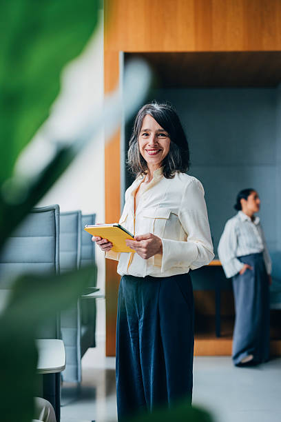 istock Professional Woman Holding Tablet While Smiling in a Modern Office Space 2218333151
