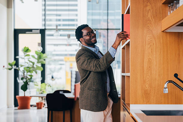 istock Professional Man Organizing Shelves in a Modern Office Workspace 2218333176