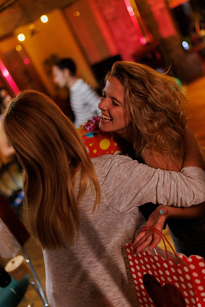 Young friends laughing and walking together amidst crowd at summer outdoor music festival