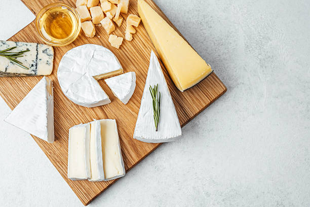 istock Cheese platter featuring various types of cheese and honey on wooden board 2218340709