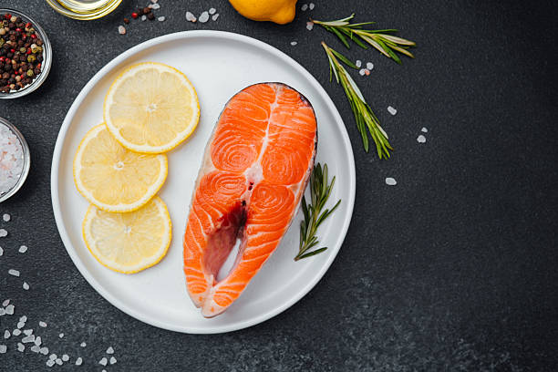 istock Fresh salmon steak prepared with lemon and herbs on a kitchen countertop 2218340746