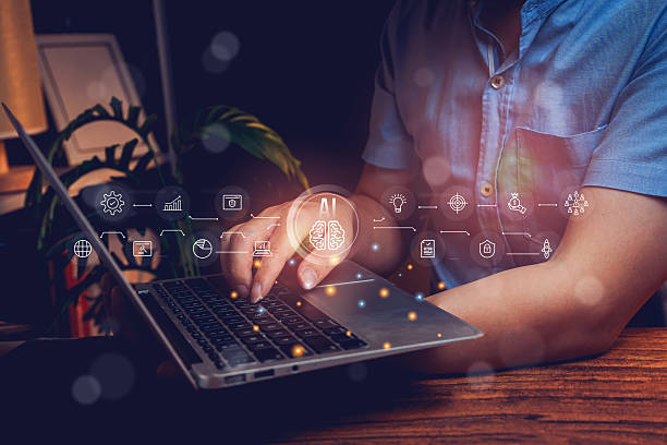 istock Ai concept. Businessman using laptop with AI graphics and digital icons in modern workspace during nighttime atmosphere 2218342535