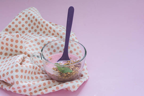 yogurt with granola and mint in a glass cup